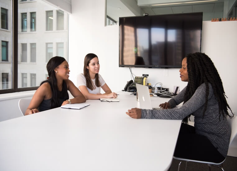 Human Resources Two women sitting across an office desk from a human resources employee