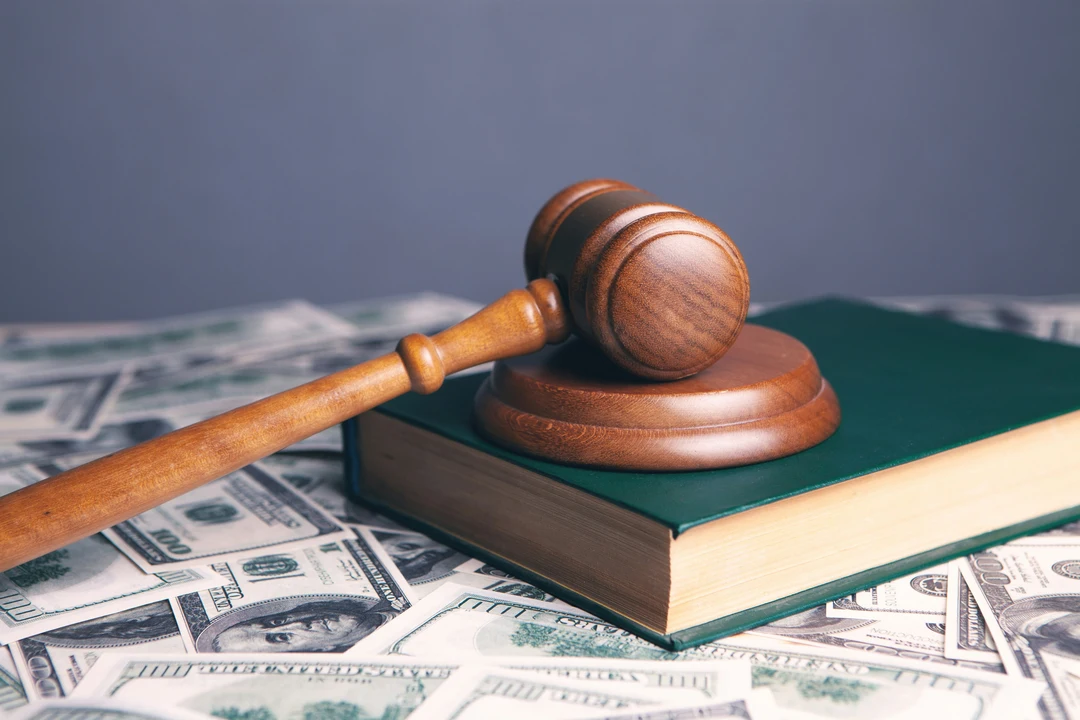 Wooden gavel resting on top of a book and a pile of money