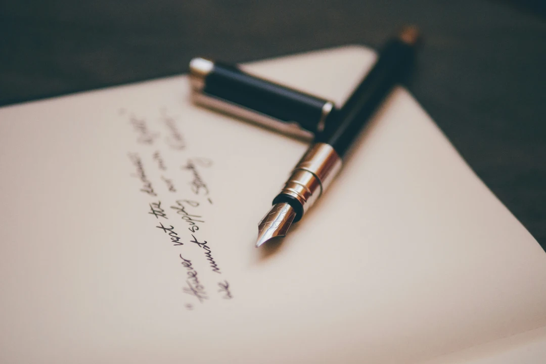 Small poem handwritten on a piece of paper with a fountain pen next to it